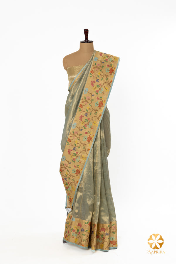 The saree gracefully draped on a mannequin, revealing its artistic border.