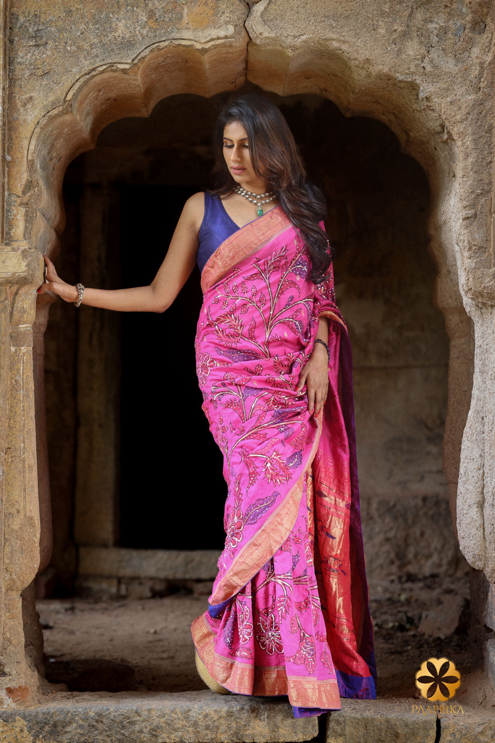 Hot Pink Paithani Silk Saree with Kalamkari and Sequin Embroidery paired with complementary accessories. The saree's vibrant pink hue, artistic intricacy, and shimmering sequins create a captivating ensemble, perfectly complemented by the accessories for a complete and stylish appearance.