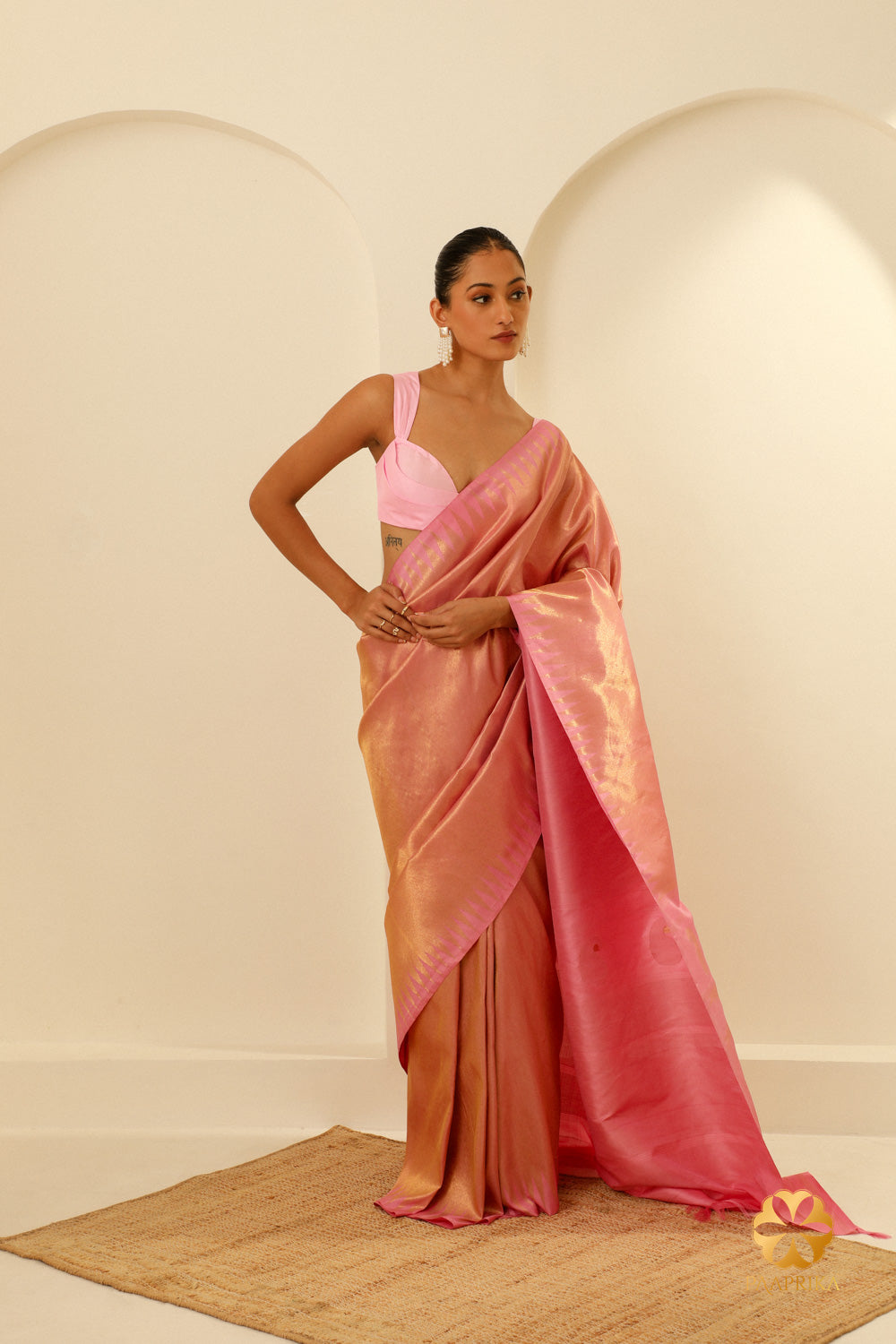 A stylish woman wearing the Pastel Pink Kanjivaram Handwoven Saree, radiating elegance and charm at a special occasion.