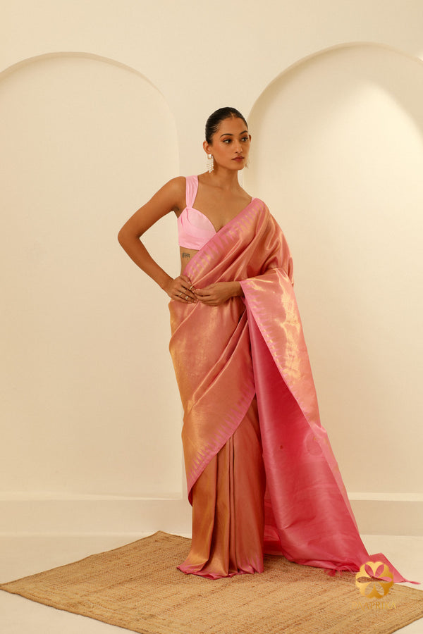 A stylish woman wearing the Pastel Pink Kanjivaram Handwoven Saree, radiating elegance and charm at a special occasion.