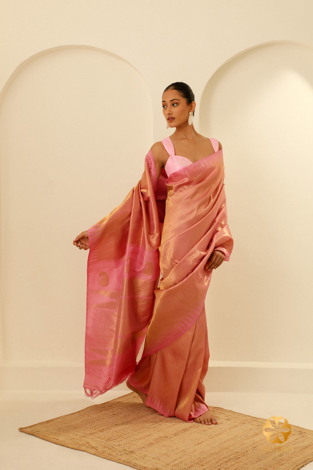 The graceful drape of the saree, highlighting the Zari Pillaiyar Mokku Motif and the elegant pastel pink hue.