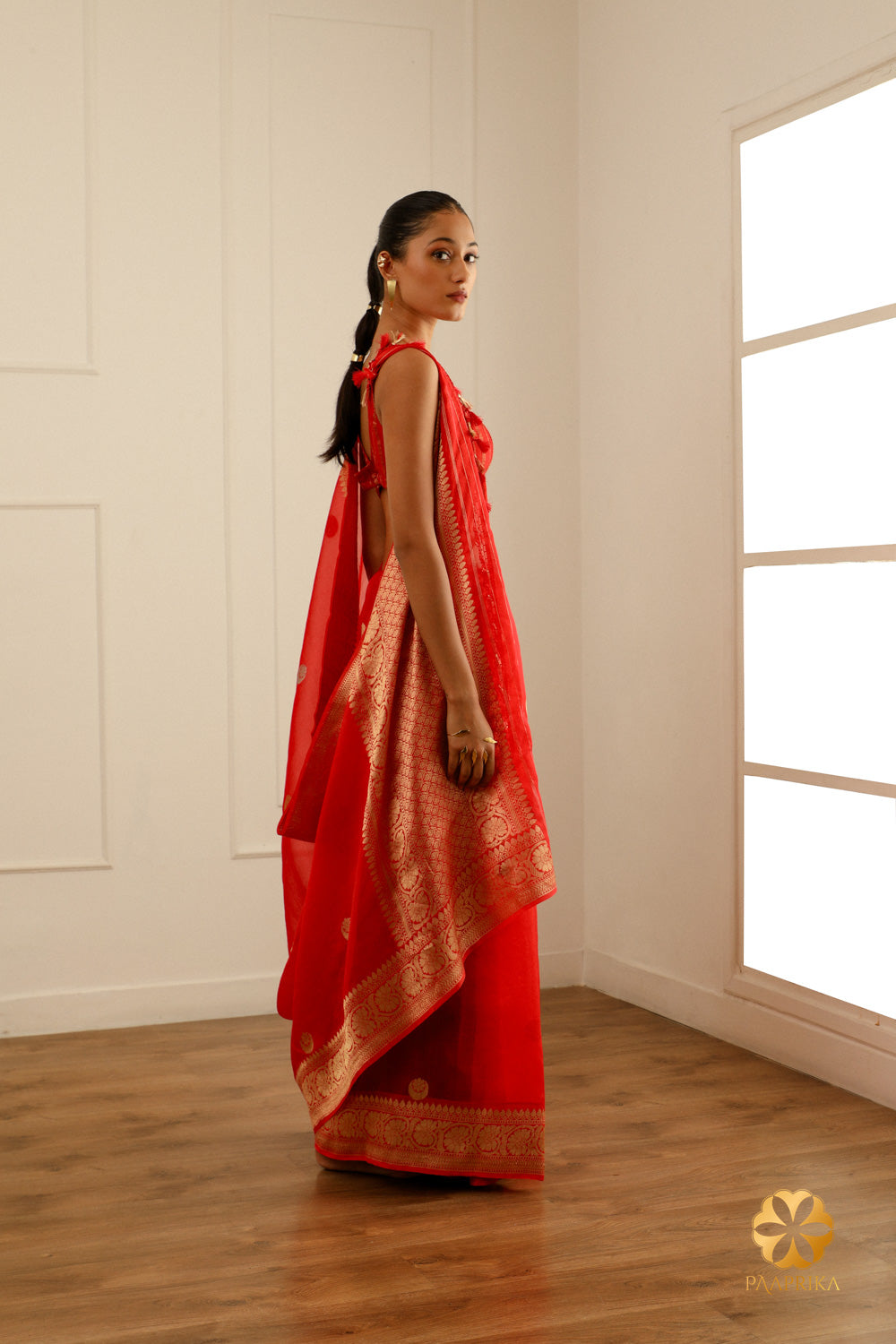 A side view of the saree showcasing its striking red hue and delicate Kora Organza fabric.