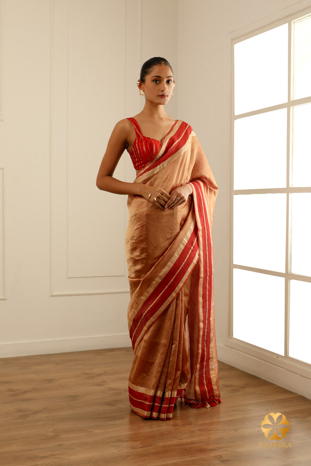  A full-length shot of a woman gracefully wearing the Burgundy Tissue Saree, showcasing its beauty and sophistication.