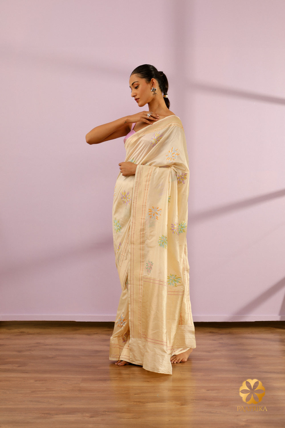 A shot of the saree's pallu, showcasing the continuation of the pastel floral motifs and the overall design that adds to its elegance.