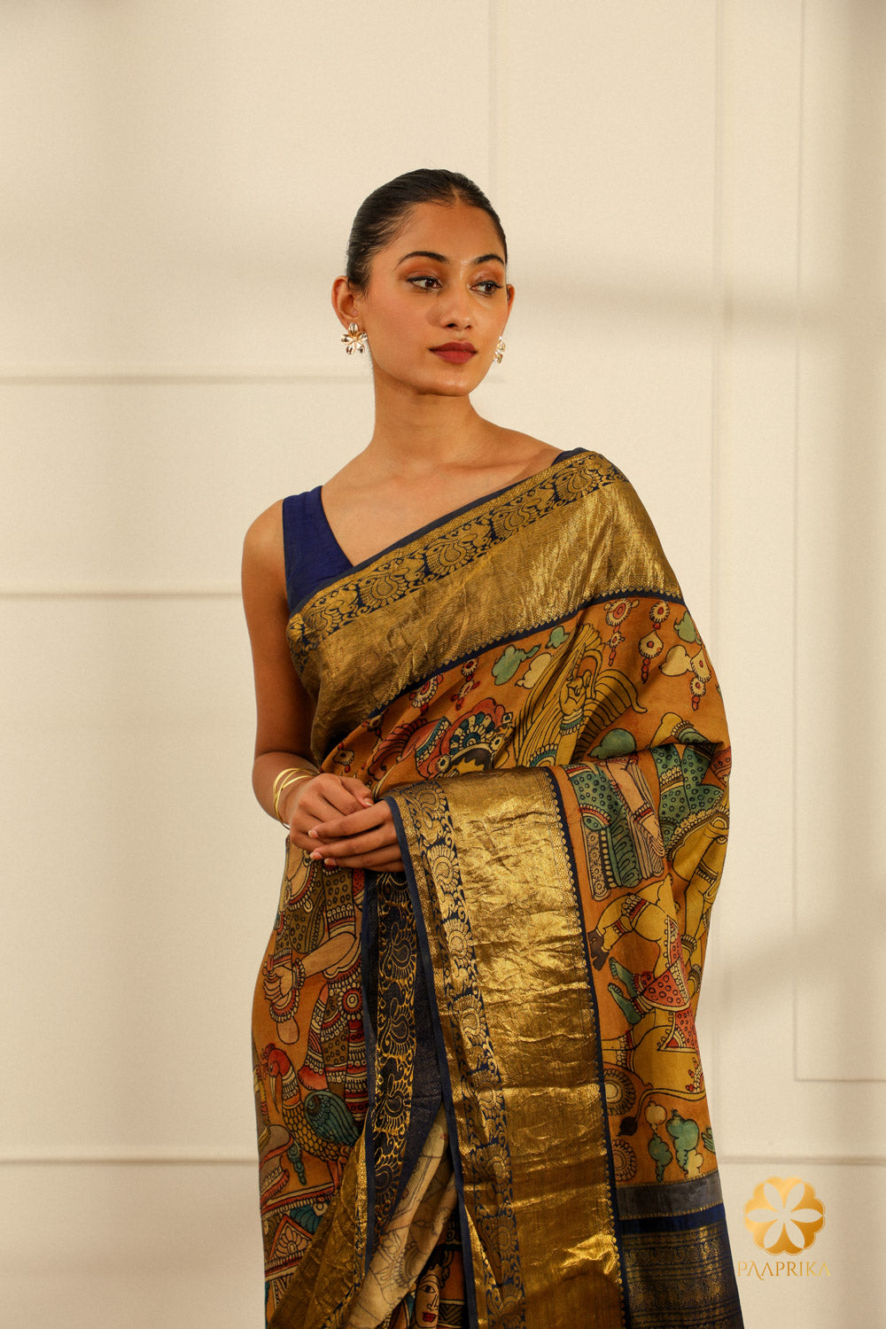 The saree elegantly displayed on a mannequin, capturing the beauty of the Kalamkari design and the peacock motifs on the border.