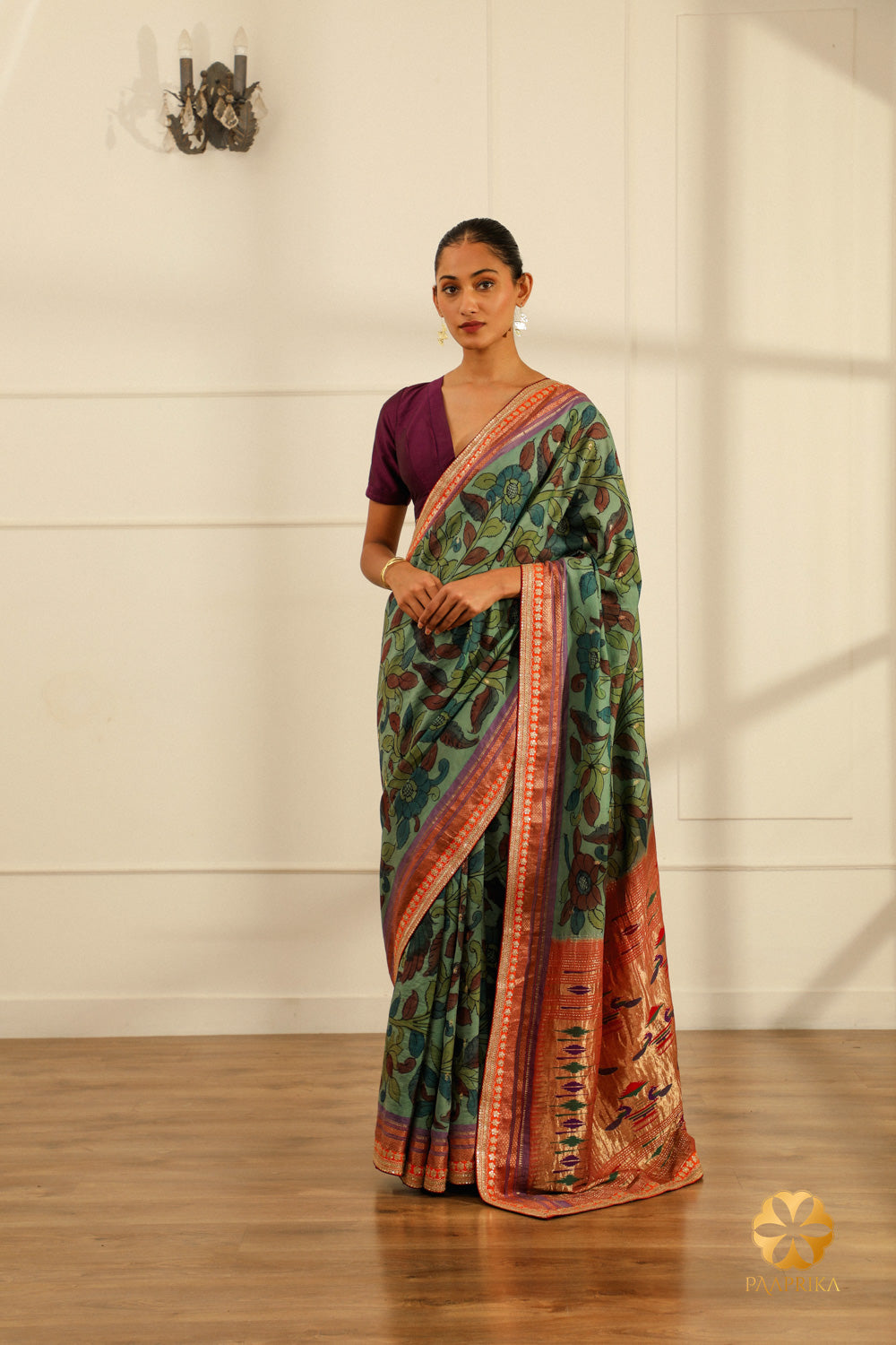 A full-length shot of a woman gracefully draped in the Aqua Blue Paithani saree, radiating elegance and artistry.