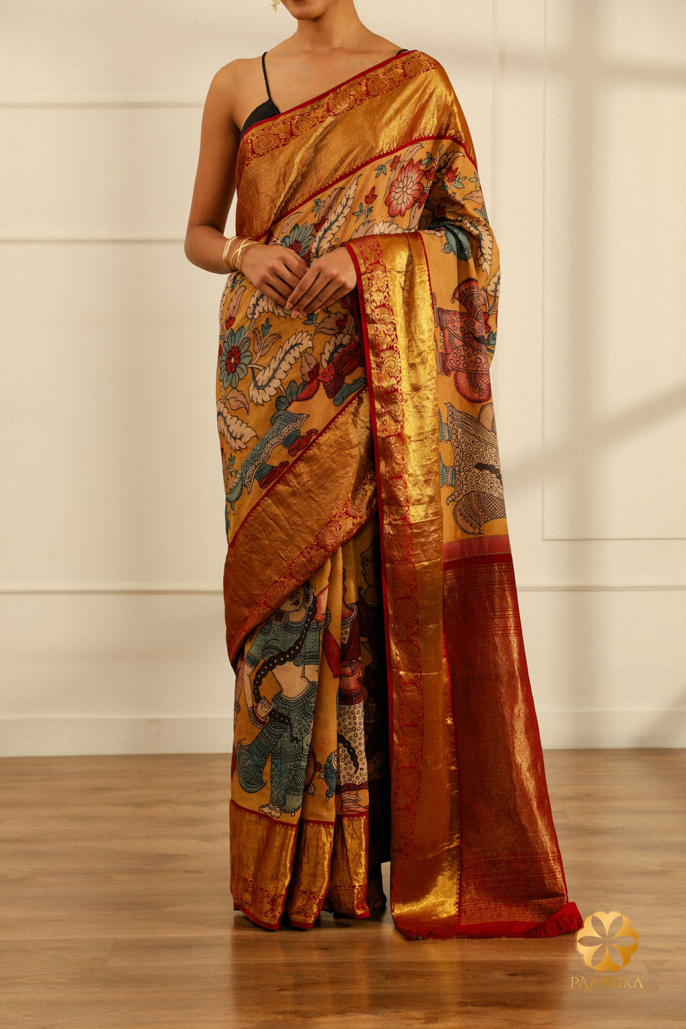  The saree elegantly displayed on a mannequin, capturing the beauty of the Kalamkari design and the silk's sheen.