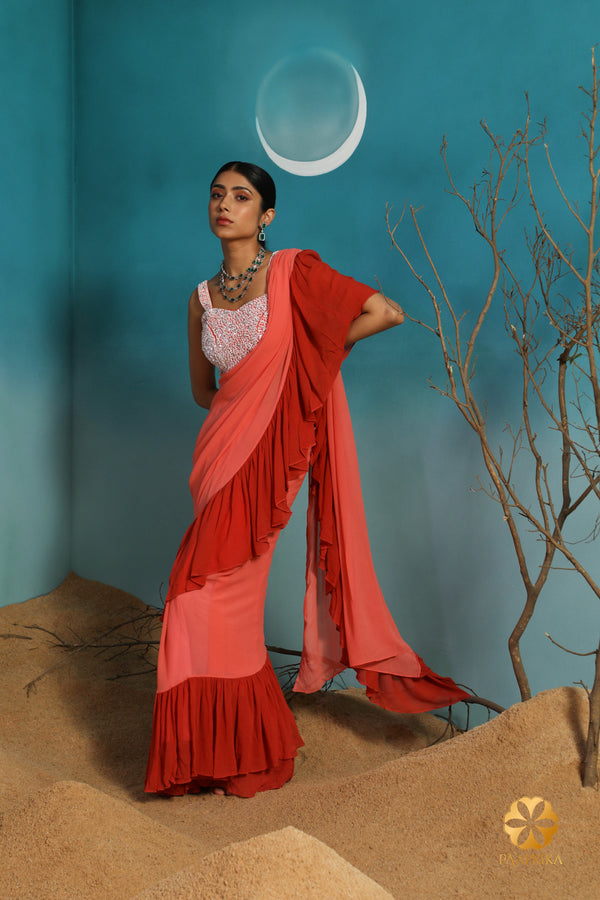 Enchanting Coral Ombre Ruffle Georgette Saree, a captivating choice showcasing fluid elegance. Paired with an embroidered blouse for a mesmerizing look.