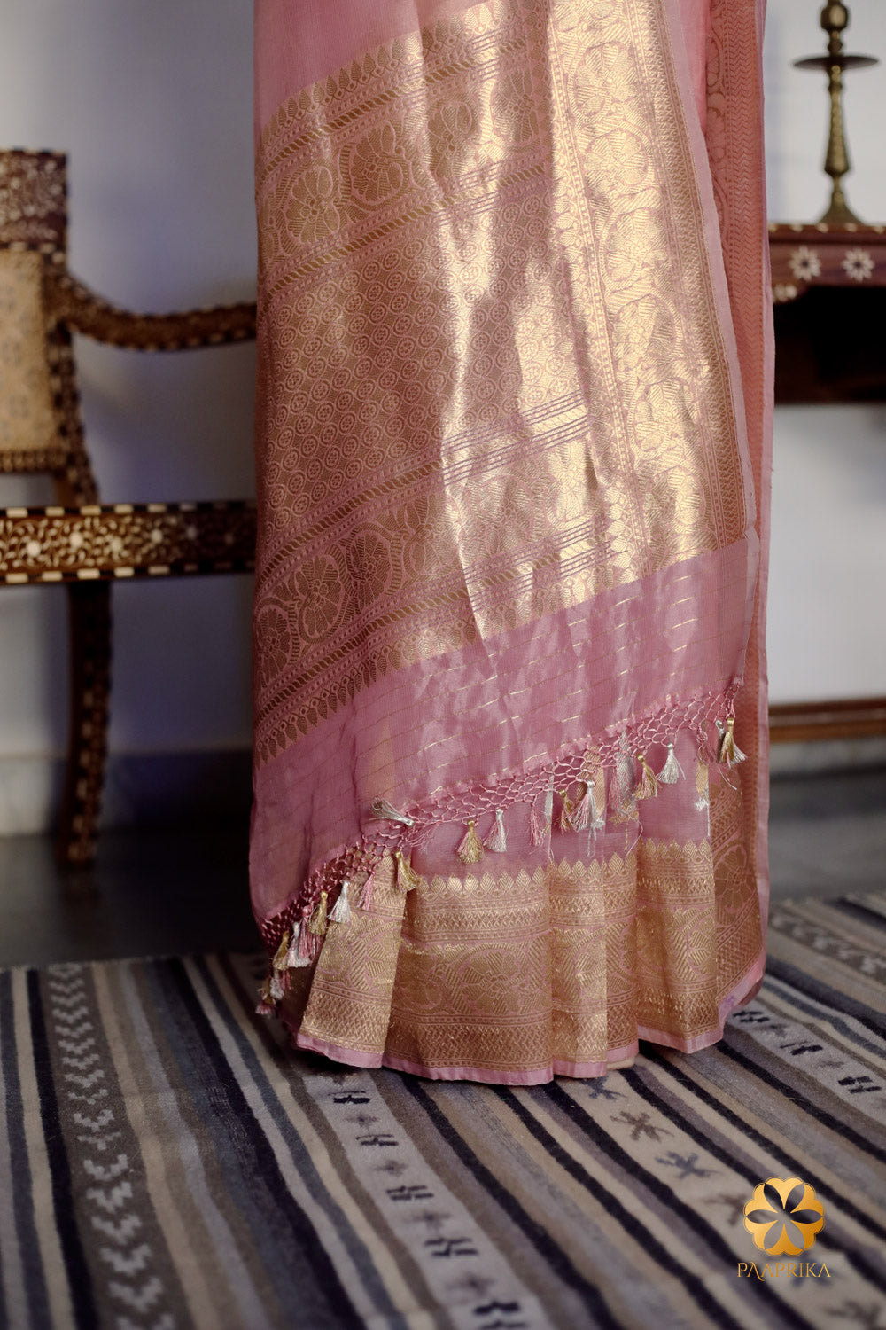 A stylish woman confidently wearing the Pastel Onion Pink Banarasi Organza Saree, embracing the delicate handwoven elegance. The saree's pastel pink color and intricate design enhance her overall look, radiating grace and sophistication.