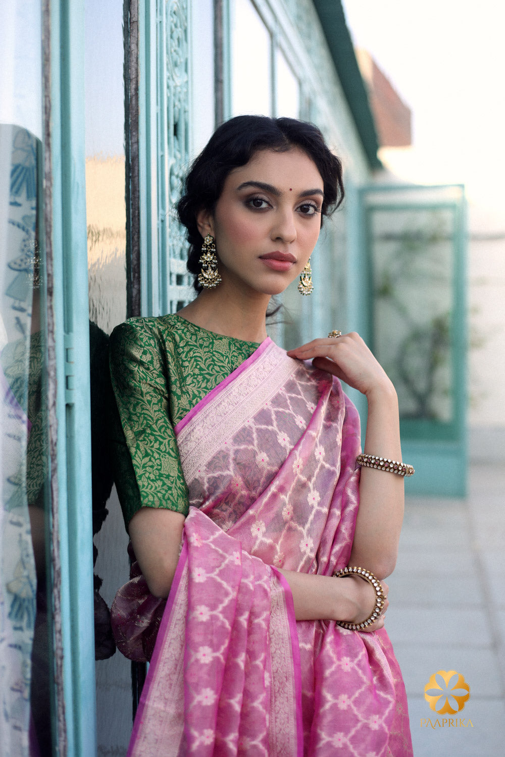 A graceful draping of the pink and gold tissue saree on a mannequin, highlighting its lightweight and airy nature, as it accentuates the wearer's curves.