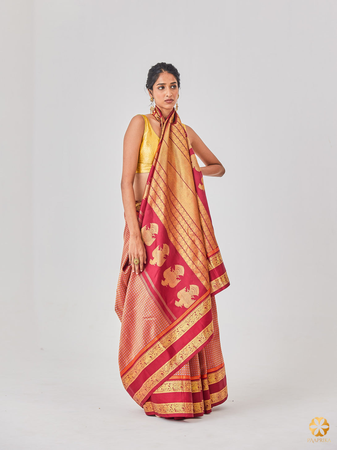 Beautiful Drape of Regal Maroon Kanjivaram Saree - Luxurious Silk Fabric with Traditional Motifs.