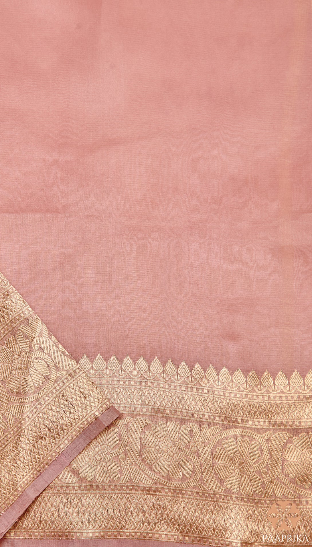 Pastel Onion Pink Banarasi Organza Saree paired with complementary accessories. The saree's delicate pastel hue and intricate handwoven pattern create a stunning ensemble, harmoniously complemented by the accessories for a complete and elegant appearance.