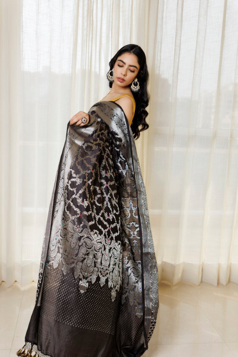 Elegant Black & Silver Pure Spunsilk Saree paired with complementary silver accessories. The combination of the saree's black base, silver motifs, and shimmer, along with the accessories, creates a cohesive and striking ensemble.