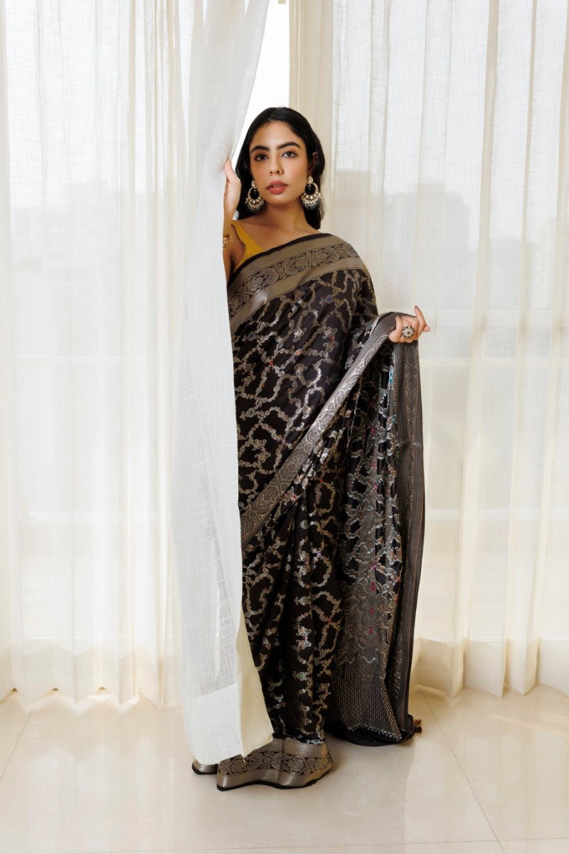 Elegant Black & Silver Pure Spunsilk Saree paired with complementary silver accessories. The combination of the saree's black base, silver motifs, and shimmer, along with the accessories, creates a cohesive and striking ensemble.