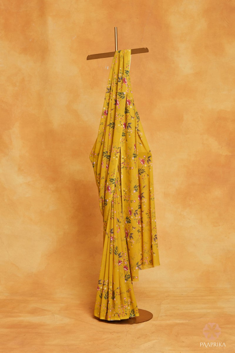 Beautiful drape of the Radiant Yellow Floral Printed Georgette Saree, embracing the sunshine with its delightful florals. The lightweight georgette fabric drapes elegantly, showcasing the captivating floral prints.