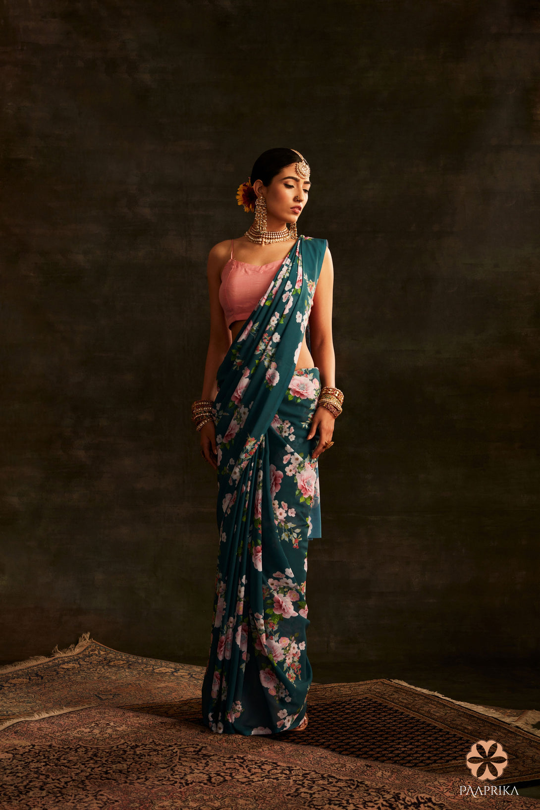 Close-up of the intricate floral print on the Exquisite Teal Green Georgette Saree. The rich teal green color and detailed floral pattern evoke a sense of serenity and elegance on the georgette fabric.