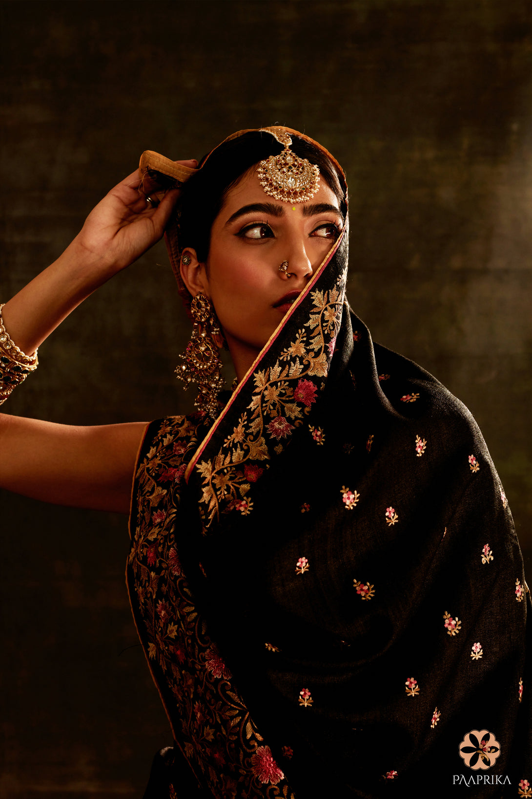  Enchanting Black Tussar Silk Floral Embroidered Saree paired with complementary accessories. The saree's black tussar silk and intricate floral embroidery create a captivating ensemble, harmoniously complemented by the accessories for a complete and enchanting look.